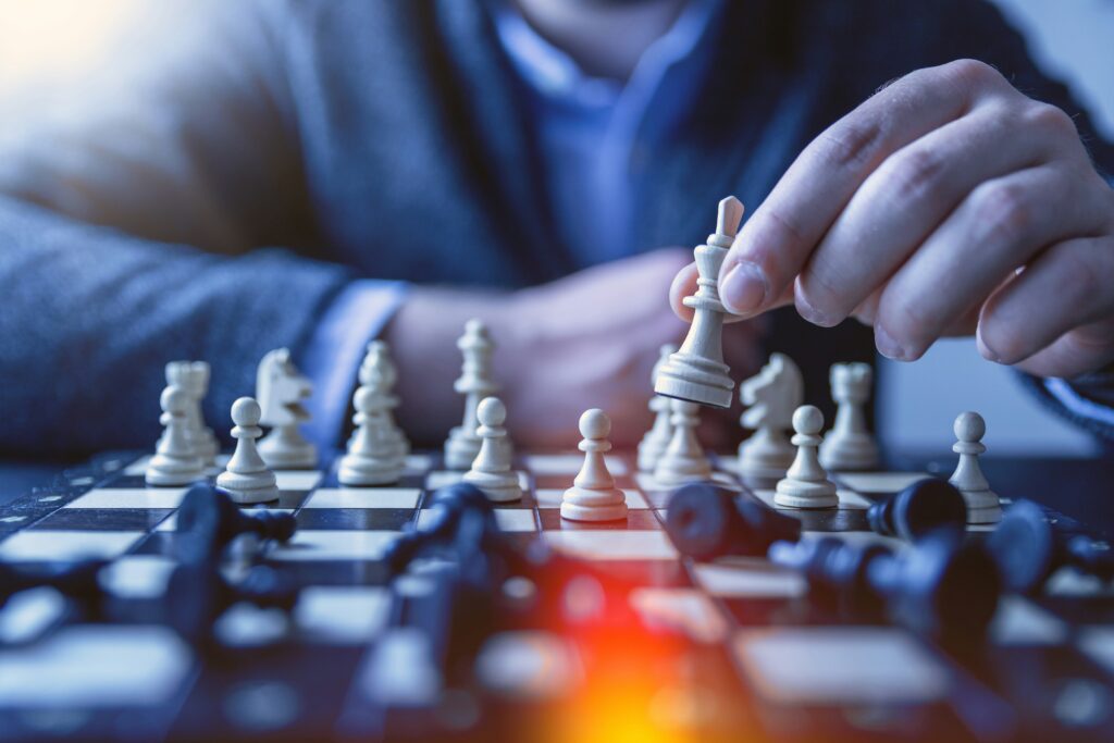Person playing chess, holding a white piece.