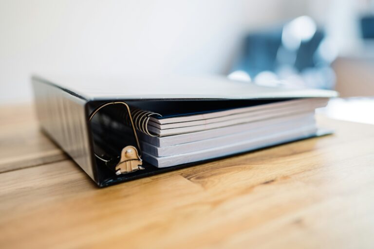 Binder filled with papers on table.