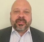 Man with beard in suit and shirt.