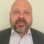 Man with beard in suit and shirt.