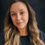 Woman with long hair, black background.